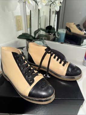 CHANEL Two-Tone Leather High-Top Sneakers in Beige & Black
